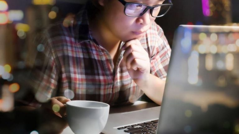 developpeur devant un ordinateur avec un cafe
